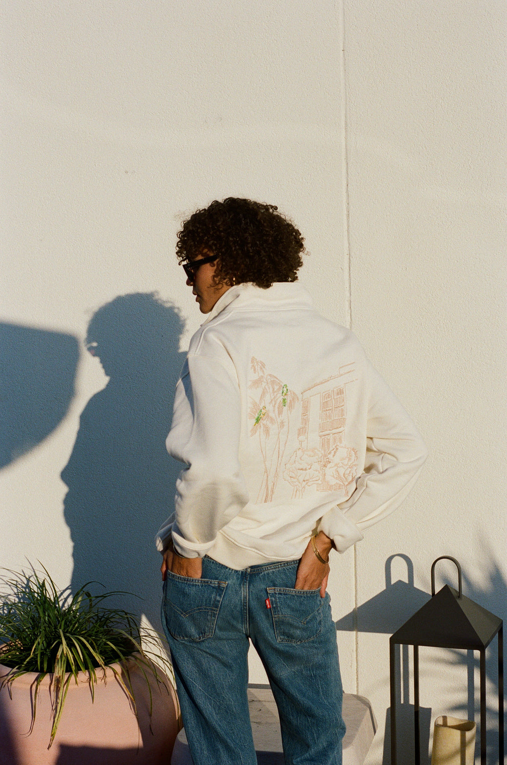 Woman wearing the L'Ermitage Beverly Hills x Dinner Service NY limited merch half zip. 