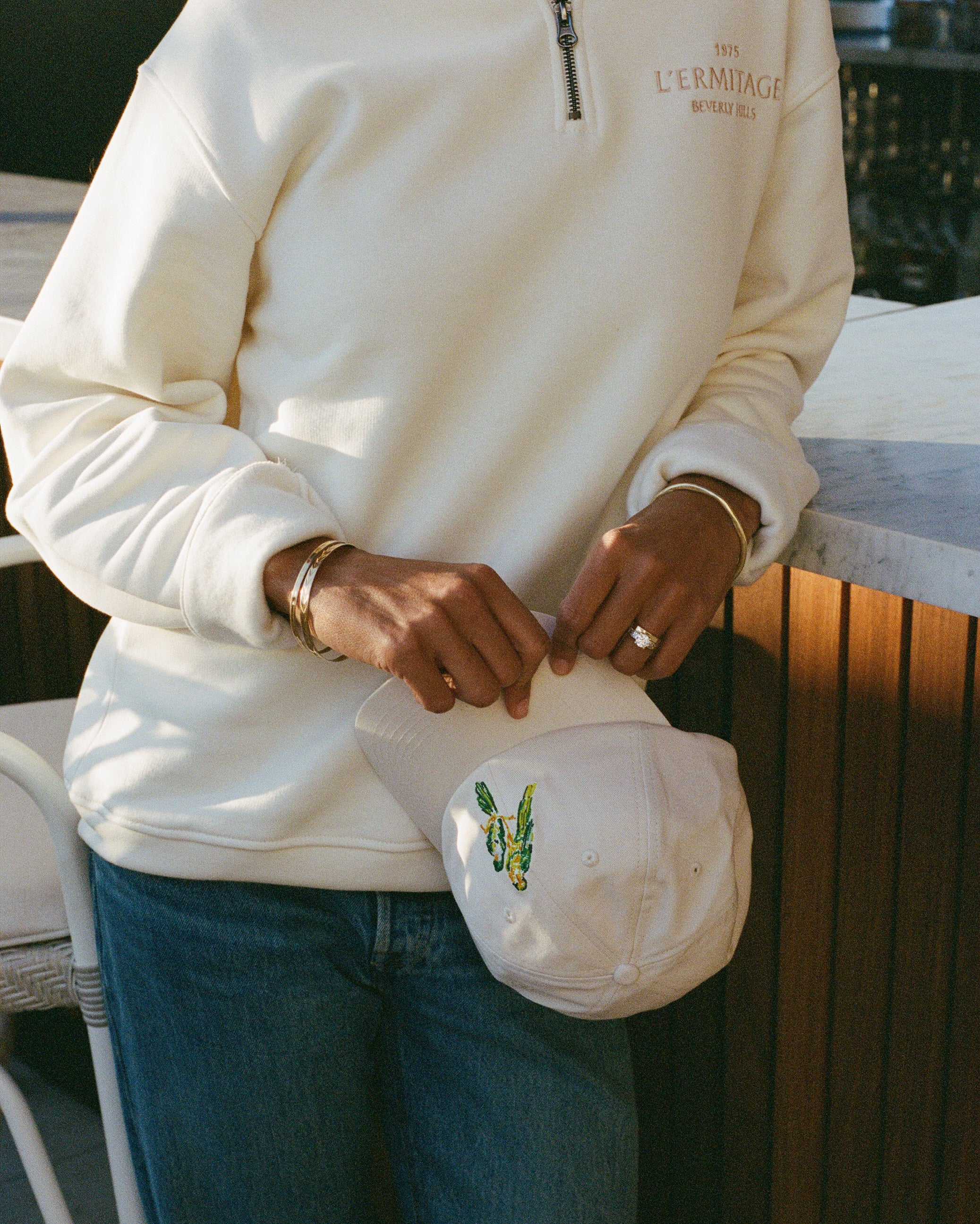 Person holding the L'Ermitage Beverly Hills x Dinner Service NY dad hat.